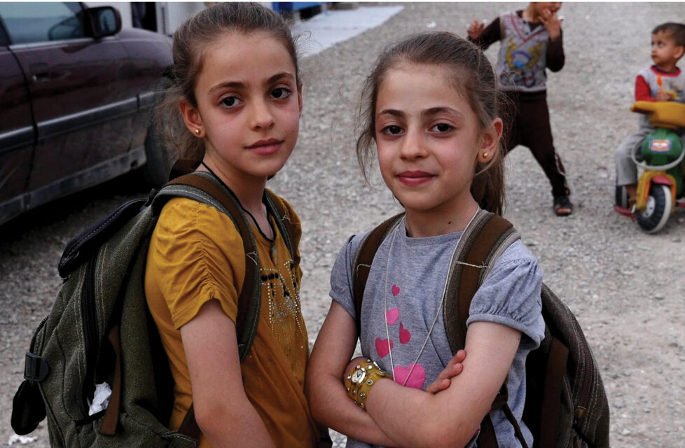 Two little girls looking at the camera smiling